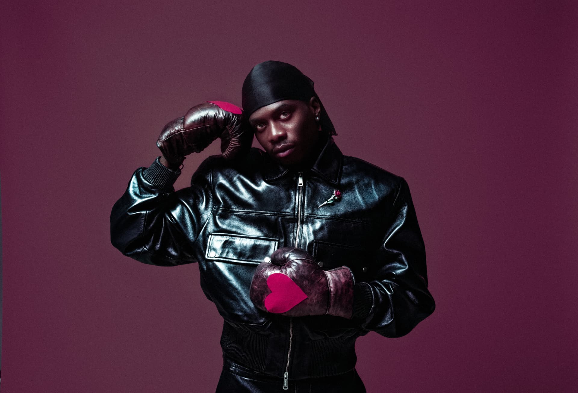 MasterPeace posed against a deep pink backdrop