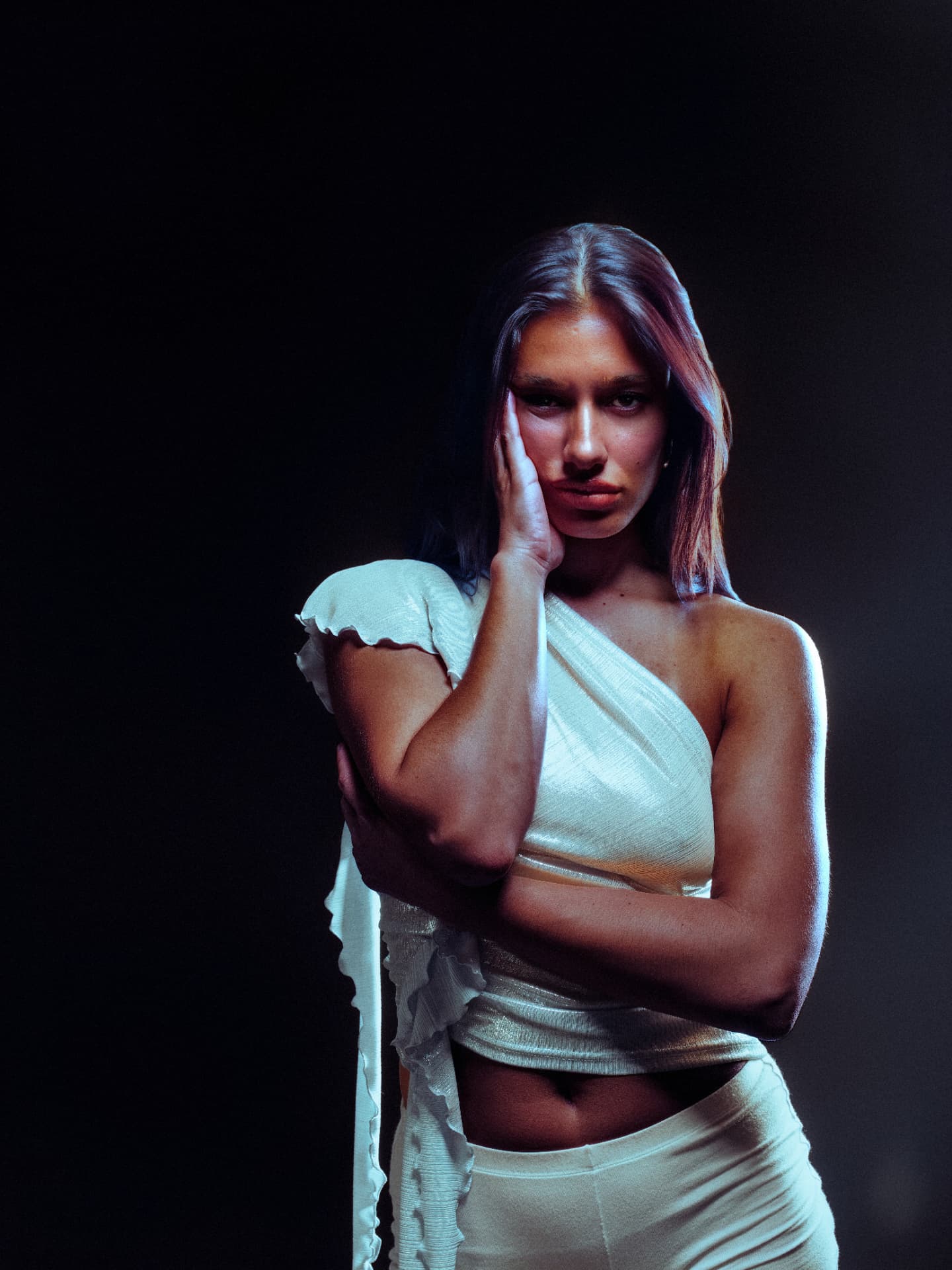 Delilah in pale satin against a dark studio backdrop