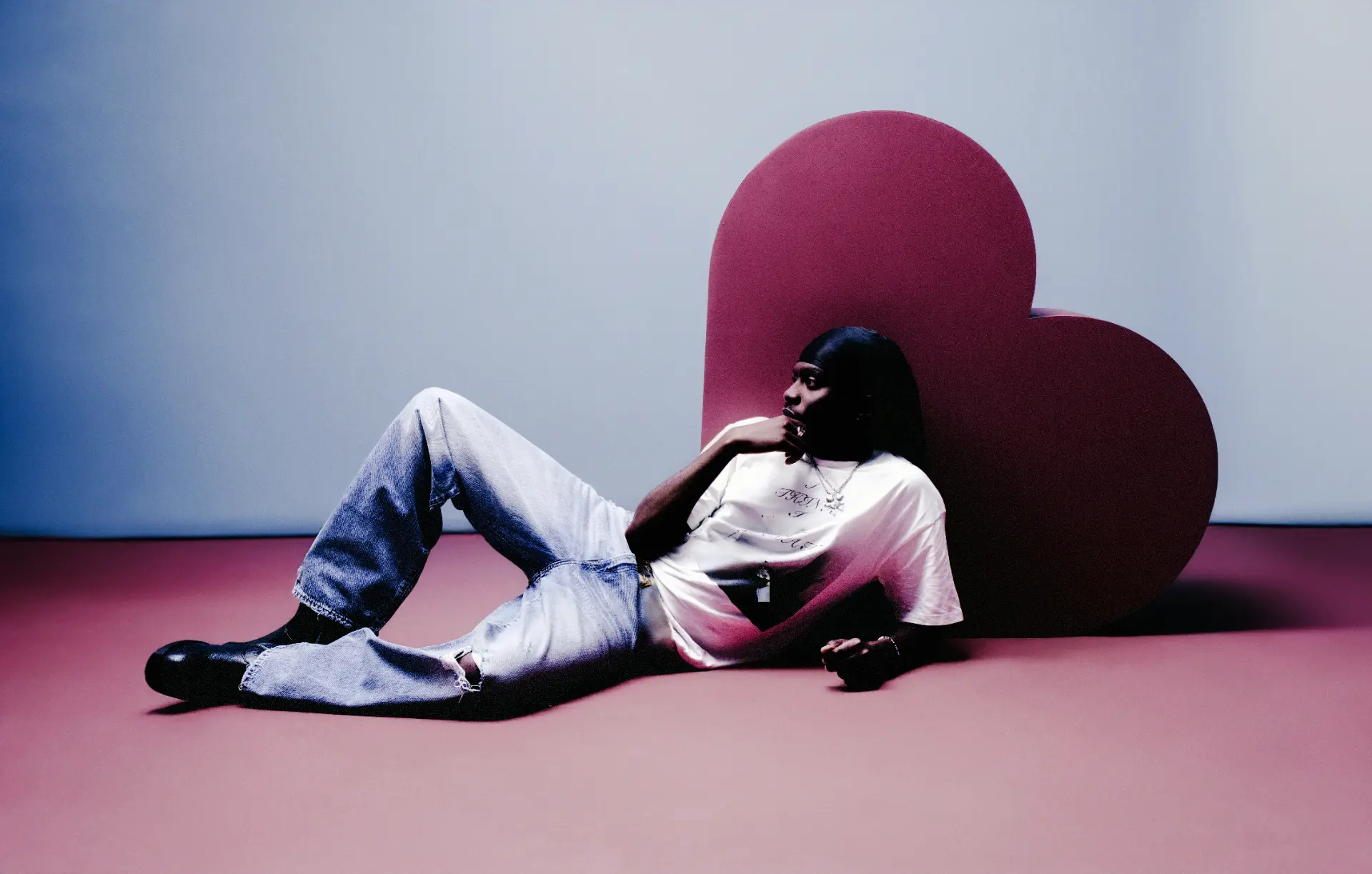 MasterPeace reclining beside a sculptural heart