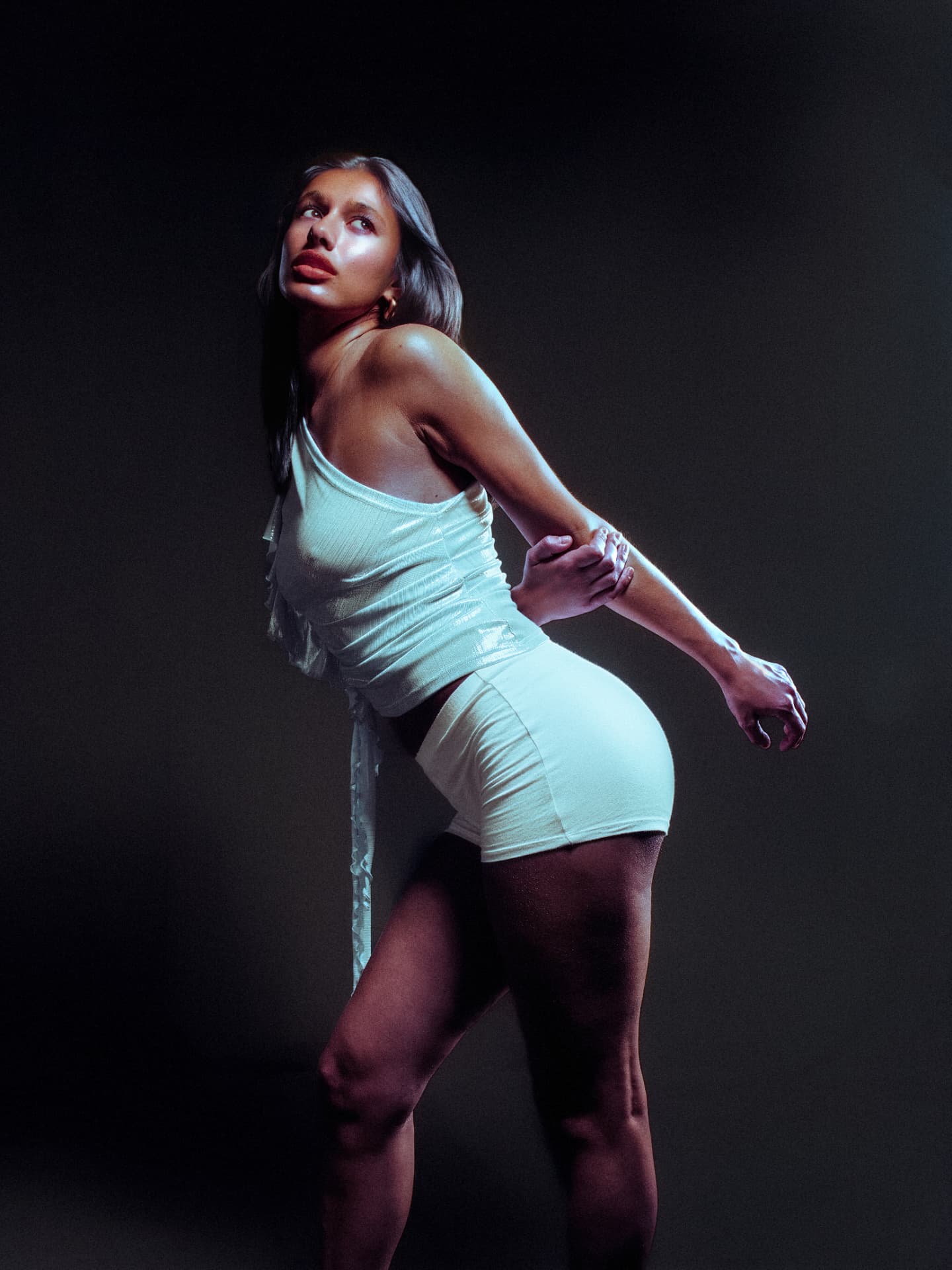 Delilah leaning into the light in pale knitwear