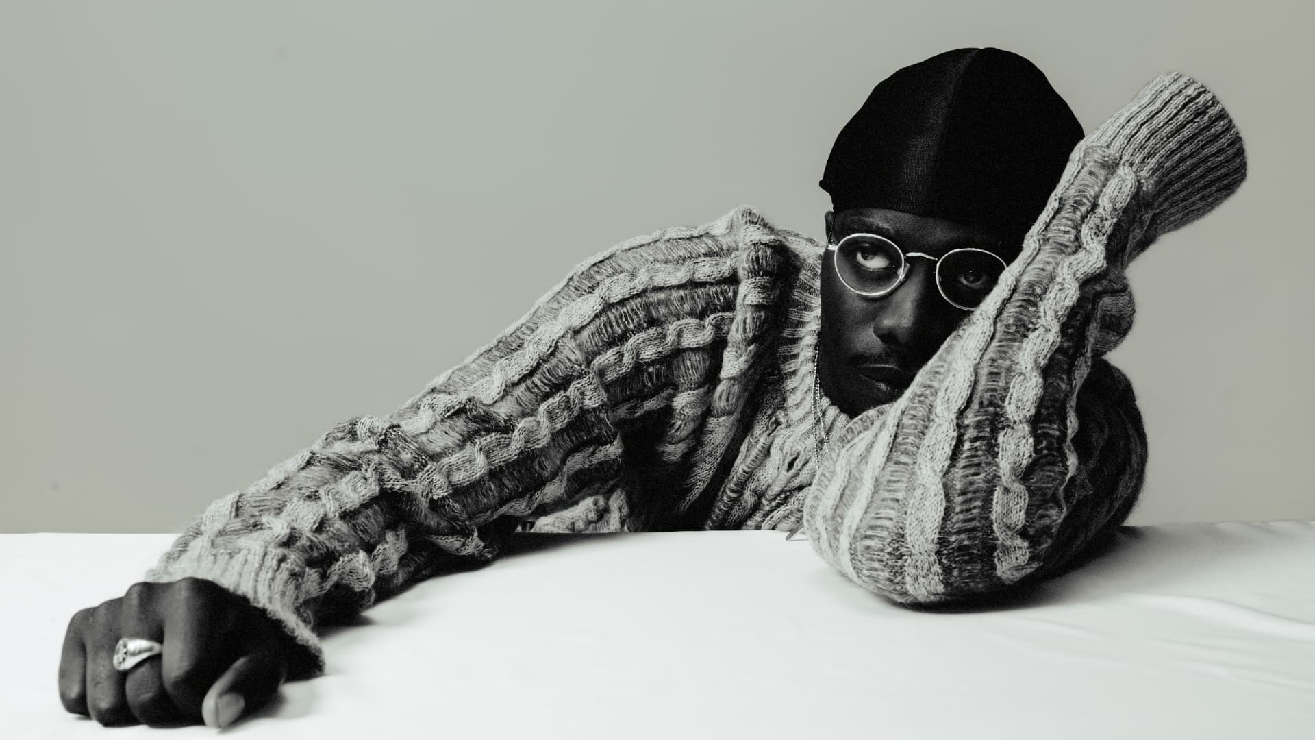 Black-and-white portrait of MasterPeace in knitwear