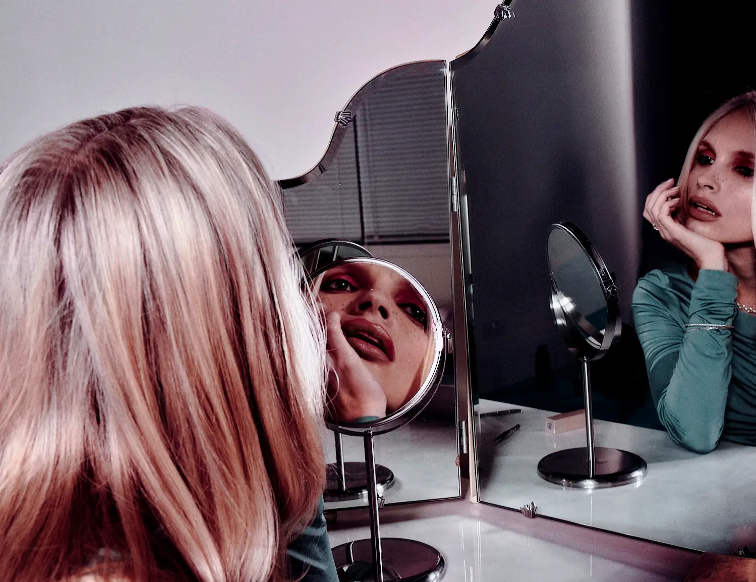 Model reflected in a triple dressing-table mirror