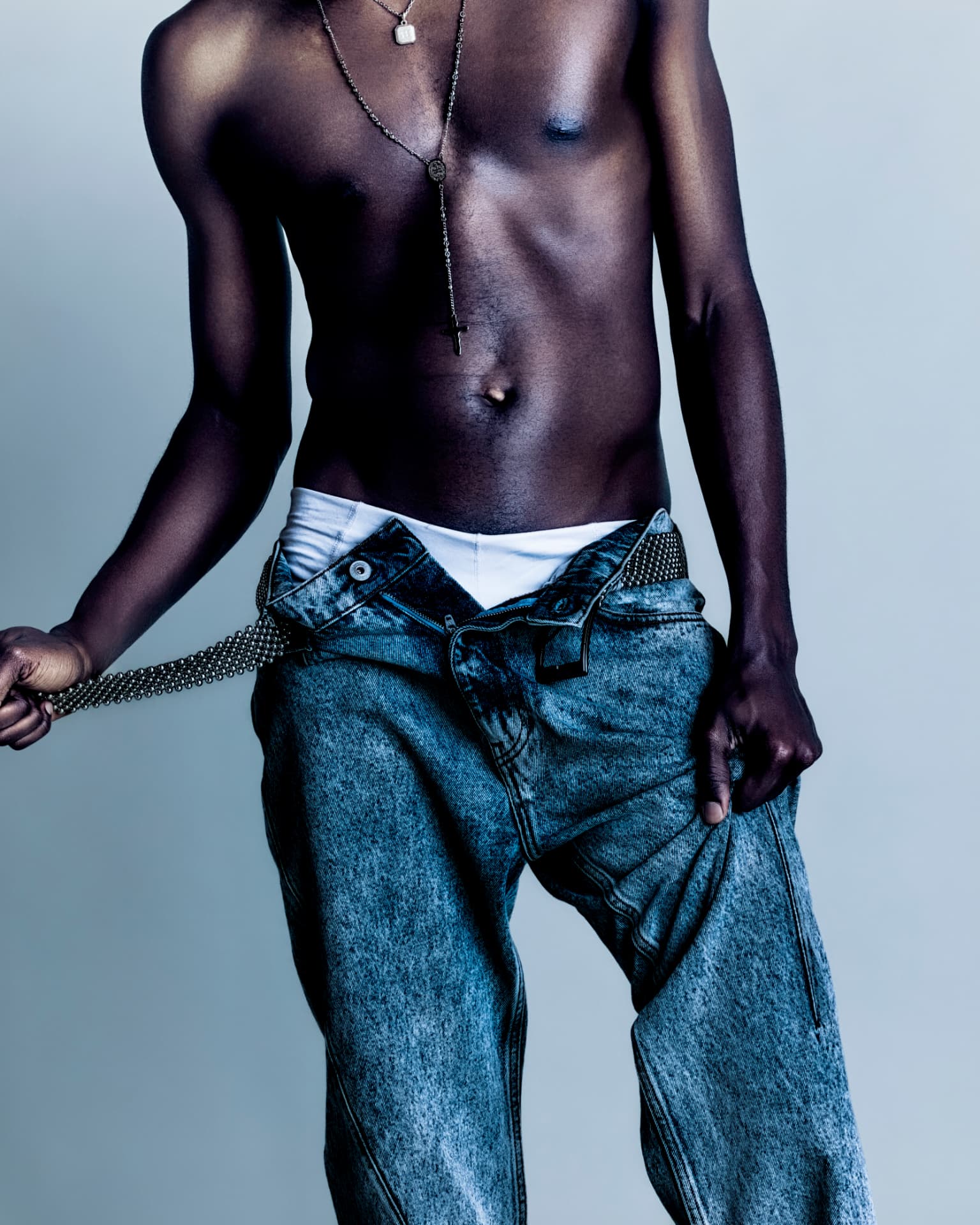 Beaded belt drawn across acid-wash denim
