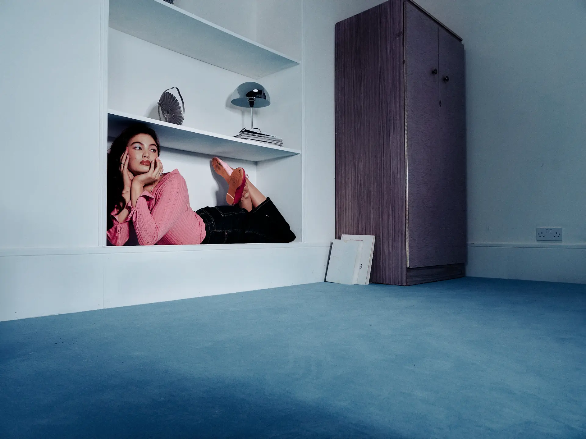 Model lying inside a white shelf recess